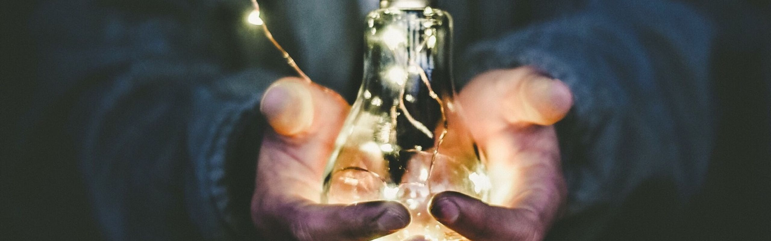 man holding incandescent bulb